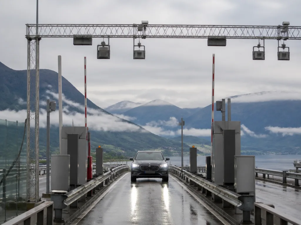 Bil som kör genom en automatisk betalstation för vägtullar på en norsk motorväg